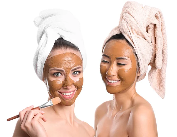 Beautiful women with facial masks on white background — Stock Photo, Image