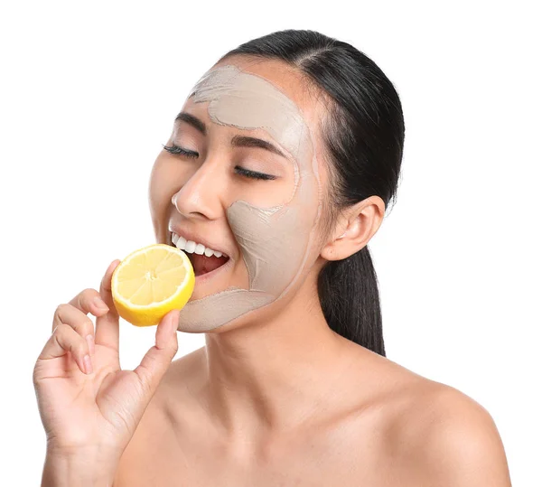 Beautiful Asian woman with facial mask and lemon on white background — Stock Photo, Image