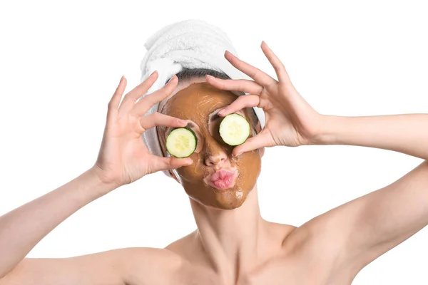 Mulher bonita com máscara facial e fatias de pepino no fundo branco — Fotografia de Stock