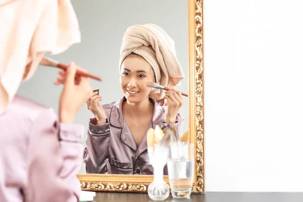 Mulher asiática bonita aplicando máscara facial em casa — Fotografia de Stock