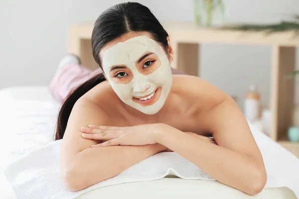 Mulher asiática bonita em tratamento com máscara facial no salão de beleza — Fotografia de Stock