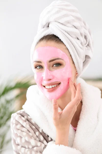 Beautiful young woman with facial mask at home — Stock Photo, Image