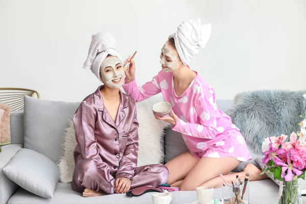 Mooie jonge vrouwen die gezichtsmaskers thuis aanbrengen — Stockfoto