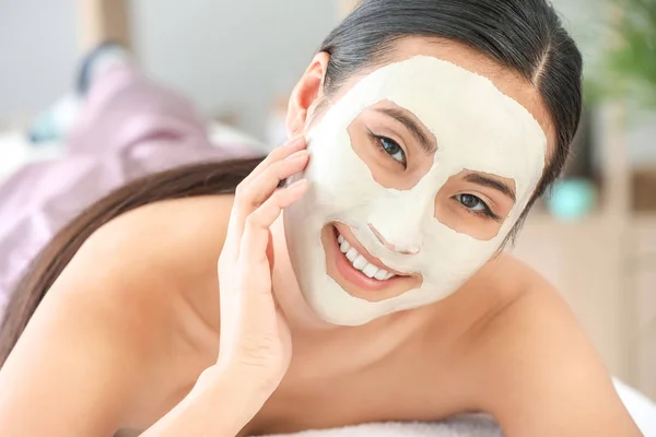 Mooie Aziatische vrouw die behandeling met gezichtsmasker in schoonheidssalon ondergaat — Stockfoto