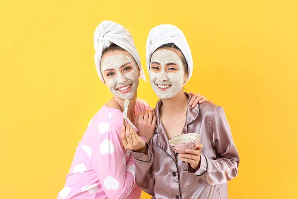 Wanita muda cantik dengan masker wajah di latar belakang warna — Stok Foto