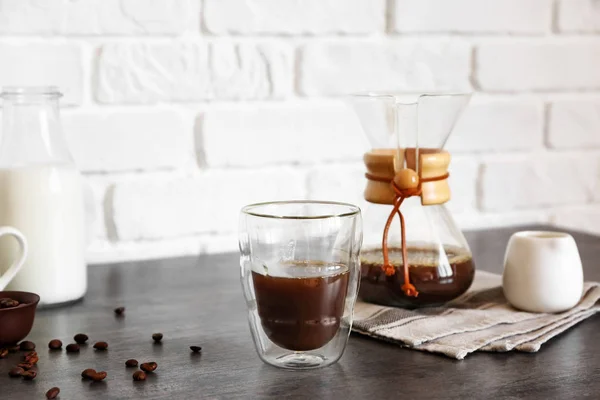 Glas hete koffie op tafel nabij bakstenen muur — Stockfoto