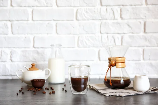 Glass of hot coffee on table near brick wall — Stock Photo, Image