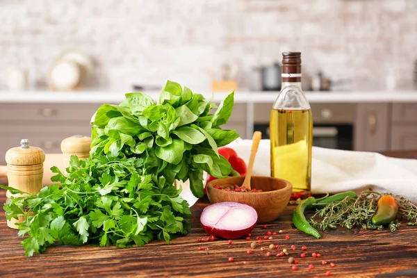 Hierbas frescas con verduras, especias y aceite en la mesa en la cocina — Foto de Stock