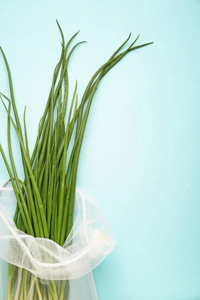 Eco bag with green onion on color background — Stock Photo, Image