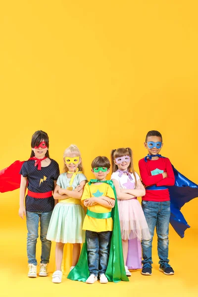 Cute little children dressed as superheroes on color background — Stock Photo, Image
