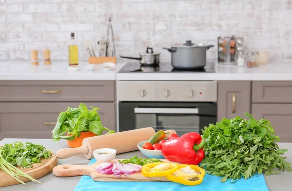 Deska s čerstvými bylinkami a zeleninou na stole v kuchyni — Stock fotografie