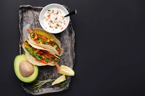 Piatto con gustosi tacos freschi e salsa su sfondo scuro — Foto Stock