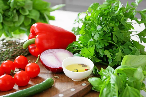 Erbe fresche con verdure e olio sul tagliere — Foto Stock