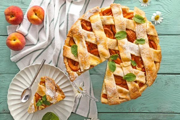 Composition with tasty peach pie on wooden background