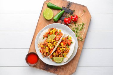 Beyaz ahşap arka plan üzerinde lezzetli tacos ile Plaka