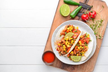 Beyaz ahşap arka plan üzerinde lezzetli tacos ile Plaka