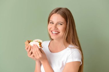 Renk arka planda lezzetli taco yeme kadın