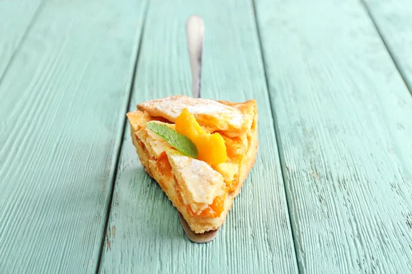 Шматок смачного персикового пирога на дерев'яному фоні — стокове фото