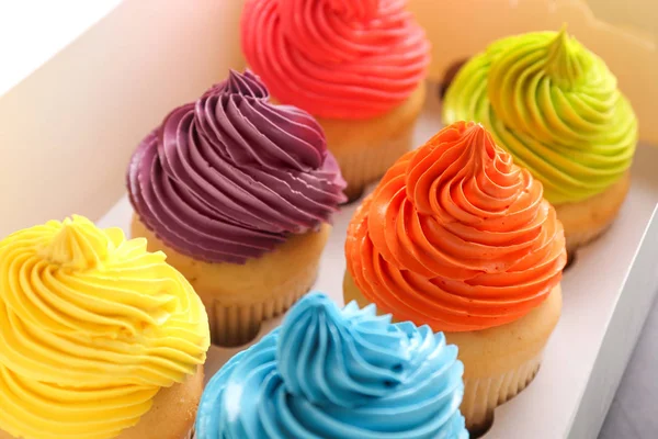 Muitos cupcakes coloridos saborosos na caixa — Fotografia de Stock
