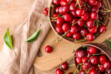 Ahşap arka plan üzerinde tatlı olgun kiraz ile Bowls