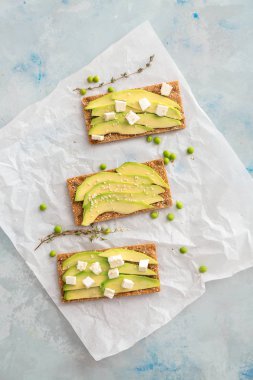 Hafif arka planda avokado ve feta ile lezzetli sandviçler