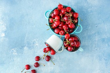 Kupalar ve renkli arka planda tatlı olgun kiraz ile pot