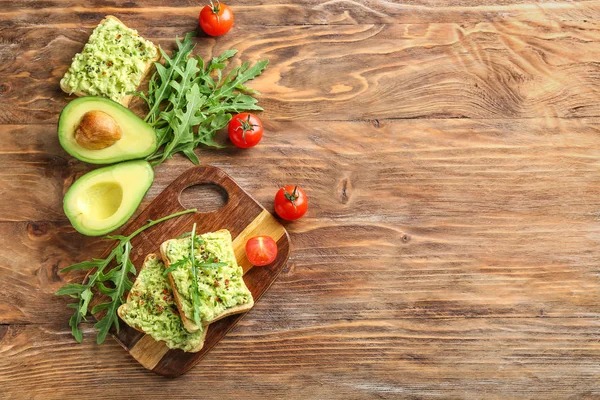 Samenstelling met lekkere avocado en broodjes op houten achtergrond — Stockfoto