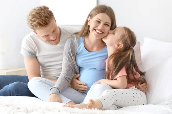 Mooie zwangere vrouw met haar familie in de slaapkamer — Stockfoto