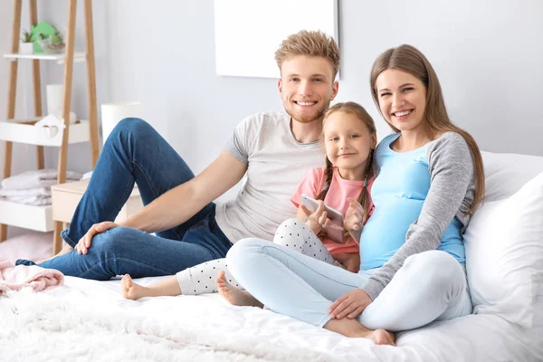 Bella donna incinta con la sua famiglia in camera da letto — Foto Stock