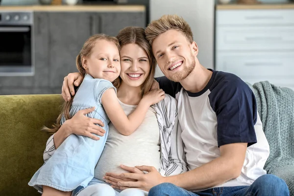 Schöne schwangere Frau mit ihrer Familie zu Hause — Stockfoto