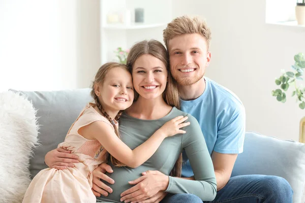 Schöne schwangere Frau mit ihrer Familie zu Hause — Stockfoto