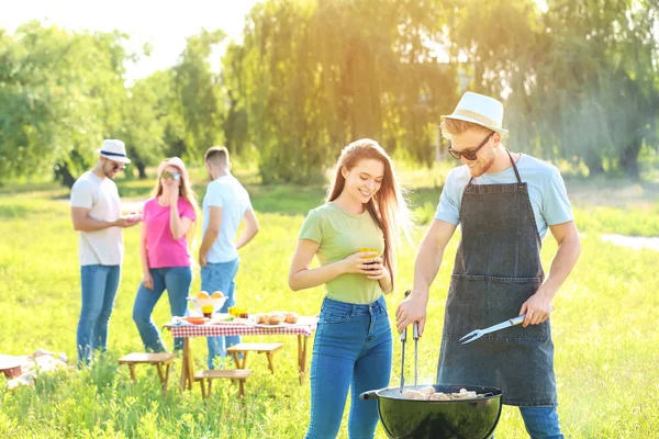 Amigos cocinando comida sabrosa en la parrilla de barbacoa al aire libre —  Fotos de Stock