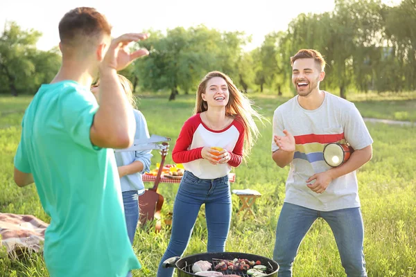Přátelé vaříte chutné pokrmy na grilu venku — Stock fotografie