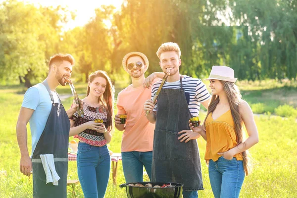 Friends cooking tasty food on barbecue grill outdoors — Stock Photo, Image