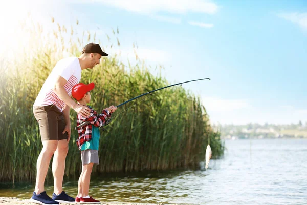 강에서 함께 고기잡이를 하고 있는 아버지 와아들 — 스톡 사진