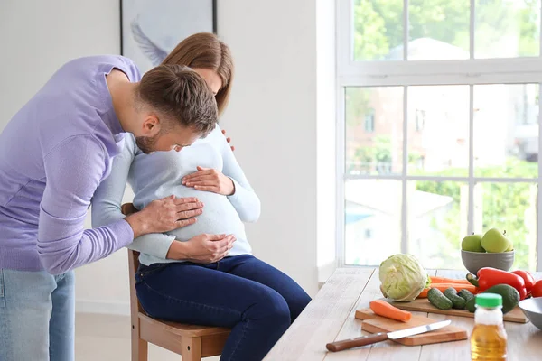 Портрет счастливой беременной пары на кухне — стоковое фото
