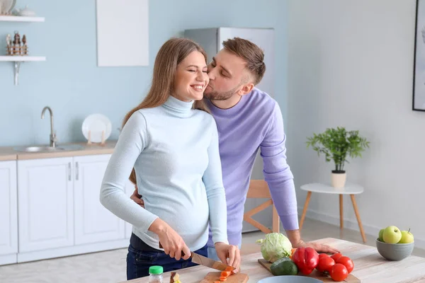 Ritratto di felice coppia incinta che cucina in cucina — Foto Stock