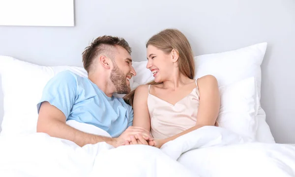 Portret van gelukkig jong stel in slaapkamer — Stockfoto