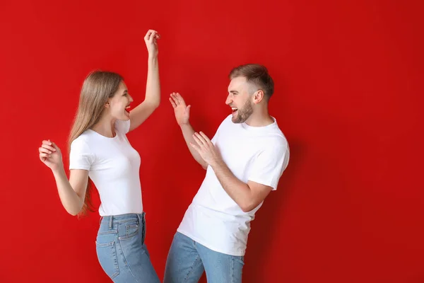 Porträtt av lyckligt ungt par som dansar mot färg bakgrund — Stockfoto