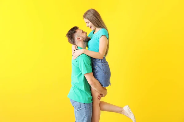 Portrait de jeune couple heureux sur fond de couleur — Photo