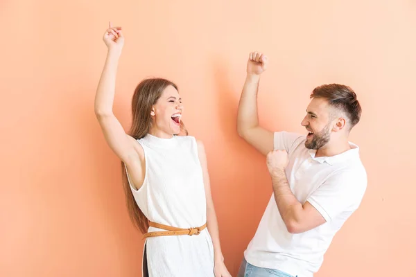 Portrait of happy dancing young couple on color background — Stock Photo, Image
