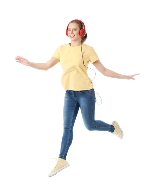 Jeune femme sautante écoutant de la musique sur fond blanc — Photo