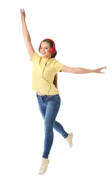 Jumping young woman listening to music on white background — Stock Photo, Image