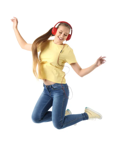 Άλμα νεαρή γυναίκα ακούγοντας μουσική σε λευκό φόντο — Φωτογραφία Αρχείου