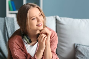 Evde kulaklık ile güzel genç kadın
