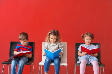 Sevimli küçük çocuklar renkli arka plan üzerinde kitap okuma