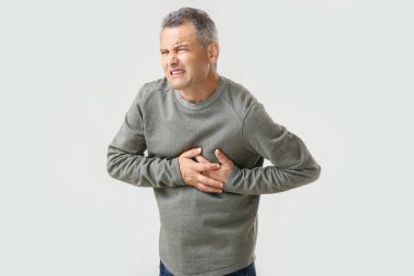 Beyaz arka planda kalp krizi muzdarip olgun adam