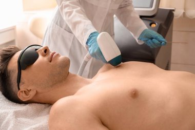 Yakışıklı adam güzellik salonunda lazer saç çıkarma prosedürü geçiyor