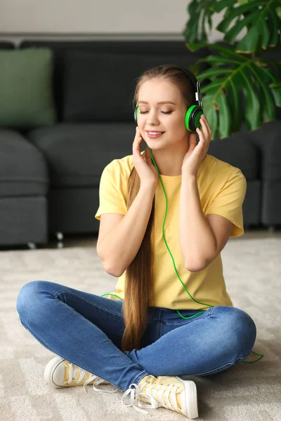 Belle jeune femme qui écoute de la musique à la maison — Photo