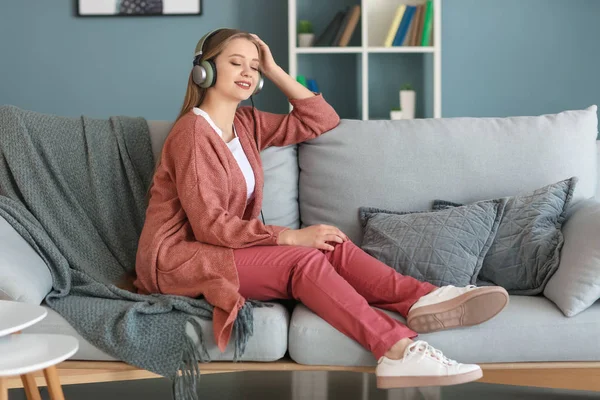 Krásná mladá žena poslouchá hudbu doma — Stock fotografie